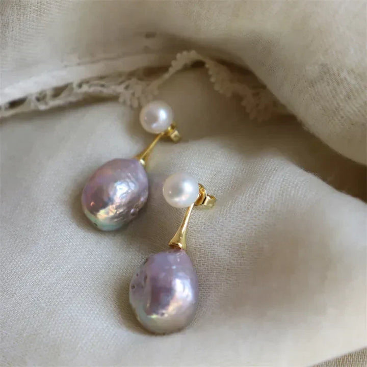 Elegant gold-coloured earrings with lilac pearl